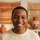 A smiling person's portrait, conveying trust and happiness, with a warm-toned background.